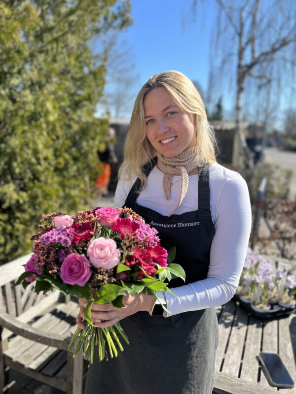 Floristen designer en smuk pink og lyserød buket i årstidens blomster.  Buketten håndbindes af floristen og bliver sammensat af Aarstidens Blomster, derfor kan det endelige resultat variere fra billedet med er i samme stilart. Kontakt os venligst endelig, såfremt du har bestemte ønsker, eller blomster du er allergisk overfor, eller ikke ønsker, beder vi dig skrive  i bemærkningsfeltet på din bestilling, og meget gerne kontakte os på telefon 60606578. 